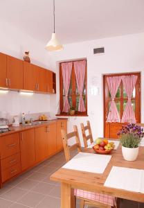 a kitchen with a table with a bowl of fruit on it at Erdődy Vendégház in Kastélyosdombó