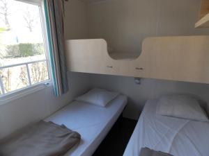 サン・ミシェル・シェフ・シェフにあるCamping Insolite Le Haut Villageの窓付きの小さな部屋のベッド2台