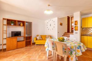 een woonkamer met een tafel en een gele bank bij Casa Pedra Longa in Santa Maria Navarrese