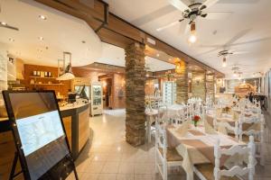 un comedor con mesas blancas y sillas blancas en Hotel Esperia, en Caorle