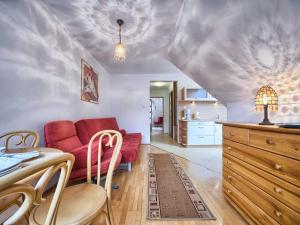 salon z czerwoną kanapą i kuchnią w obiekcie VisitZakopane - Himalaya Apartment w Zakopanem