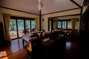 a living room with a bed and tables and chairs at Koh Mook Sivalai Beach Resort in Ko Mook