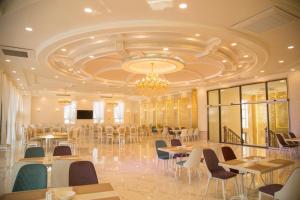 a banquet hall with tables and chairs and a chandelier at Hotel Uzbekistan in Urganch