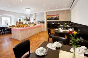 a restaurant with tables and chairs and a bar at City Apart Hotel Füssen in Füssen