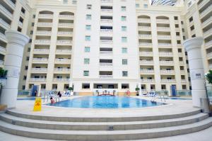 a large building with a swimming pool in front of it at KeyHost - Classy Studio - Near Five Hotel - JVC - KA650 in Dubai