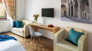 Pokój hotelowy z łóżkiem, biurkiem i telewizorem w obiekcie Cracowdays w Krakowie
