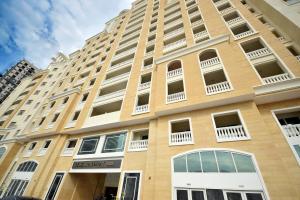 a tall tan building with windows and balconies at KeyHost - Classy Studio - Near Five Hotel - JVC - KA650 in Dubai