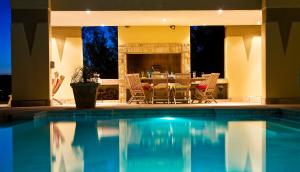 a swimming pool with a table and chairs and a fireplace at Villa Paradisa Guest House in Knysna