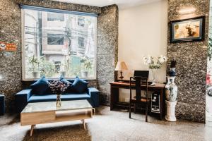 a living room with a blue couch and a desk at HANZ Sunny 2 Hotel Hanoi in Hanoi