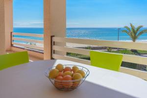 un cesto di frutta su un tavolo con vista sulla spiaggia di Residencial Guardamar Zeus a Miami Platja