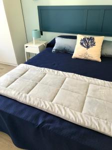 a bedroom with a large bed with a blue headboard at Il Miraggio in Fregene