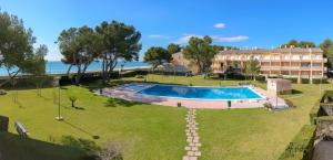 a resort with a swimming pool and a building at Residencial Guardamar Zeus in Miami Platja