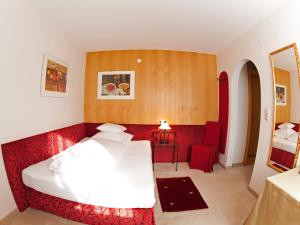 a hotel room with a bed and a chair at Pension Grissemann in Lech am Arlberg