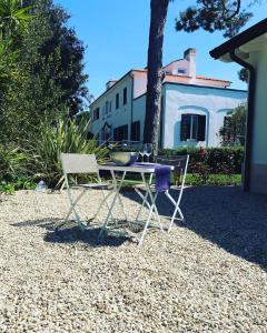 a table and a chair in front of a house at Il Miraggio in Fregene