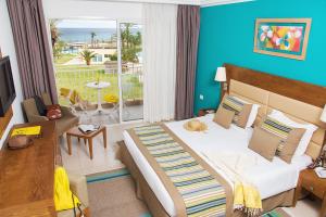 a bedroom with a large bed with a view of the ocean at AQI Skanes Resort in Monastir