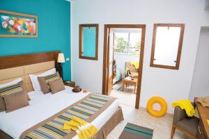 a bedroom with a large bed and a blue wall at AQI Skanes Resort in Monastir