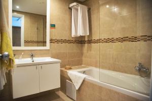 a bathroom with a tub and a sink and a bath tubermott at AQI Skanes Resort in Monastir