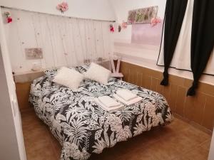 a bedroom with a bed with a black and white blanket at Los Angeles del Romero in Gátova