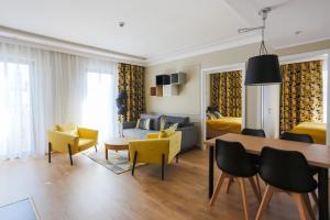 ein Wohnzimmer mit einem Esstisch und gelben Stühlen in der Unterkunft Apartamenty Świnoujście - Baltic Uzdrowiskowa 36-40 in Świnoujście