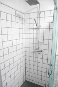 a bathroom with a shower with white tiled walls at Beautiful apartment private roof terrace in Nerja +10 photos