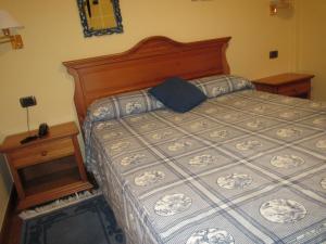 1 dormitorio con 1 cama grande y mesita de noche en Hotel Ermintxo, en Ea