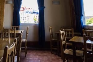 un comedor con mesas y sillas y una ventana en Hotel Ermintxo, en Ea