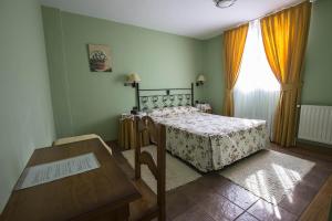 1 dormitorio con cama, mesa y ventana en Hotel Ermintxo en Ea