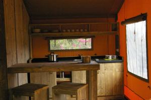 cocina con encimera con taburetes y fregadero en Càmping Parc Gualba, en Gualba de Dalt