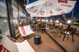 szereg stołów i krzeseł z parasolami na patio w obiekcie Hotel Gordon w Warszawie