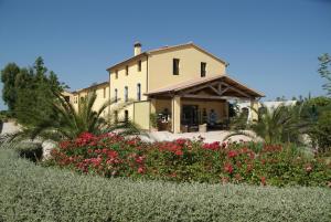 a yellow house with flowers in front of it at Campastrello Sport Hotel Residence in Castagneto Carducci