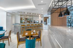 a restaurant with a table and chairs and a bar at Glyfada Riviera Hotel in Athens