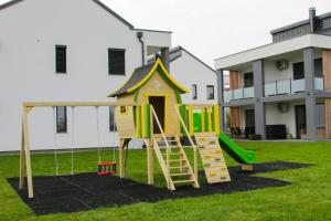 a playground in a yard with a slide at Apartma Mariposa Banovci in Banovci