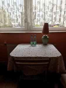 zwei Flaschen auf einem Tisch vor einem Fenster in der Unterkunft Zajazd Batory in Chorzów