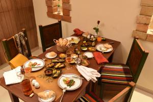 a wooden table with plates of food on it at AQI Skanes Resort in Monastir