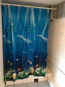 a shower curtain with an aquarium in a bathroom at Zajazd Batory in Chorzów