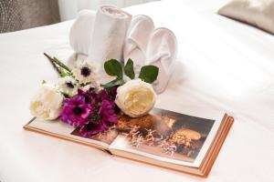 a book and flowers on a bed with a magazine at Domus Superior in Venice
