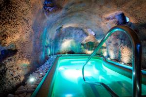 bañera de hidromasaje en una cueva con pared de piedra en Casa Rural & Spa La Graja en Chinchón