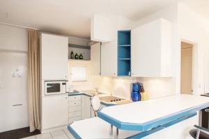 a kitchen with white cabinets and a table in it at ParkView Apartment 1 in Berlin