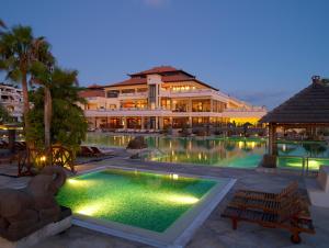 un hotel con piscina frente a un edificio en Regency Country Club, Apartments Suites en Playa de las Américas