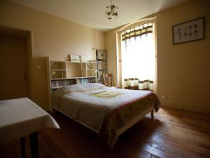 1 dormitorio con cama y ventana en Le Relais du Passe-Heures, en Cenans