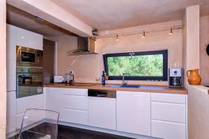 a kitchen with white cabinets and a window at Mai's Villa in Stari Grad