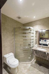 y baño con aseo, lavabo y ducha. en Onizah Hotel en Unayzah
