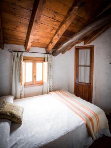 Casa Rural & Spa La Graja في تشينتشون: غرفة نوم مع سرير أبيض كبير مع نافذة