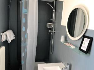 a bathroom with a shower and a sink and a mirror at Hôtel L'Estran in Trouville-sur-Mer +51 photos
