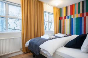 1 dormitorio con 1 cama y una pared colorida en Thingholt Apartments en Reikiavik