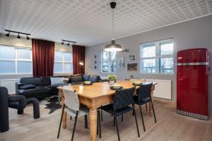 ein Wohnzimmer mit einem Tisch und einem roten Kühlschrank in der Unterkunft Thingholt Apartments in Reykjavík