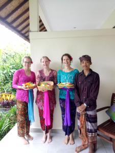 um grupo de três mulheres e um homem segurando pratos em Krisda Ubud Guest House em Ubud