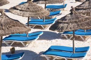 a group of chairs and umbrellas on a beach at AQI Skanes Resort in Monastir