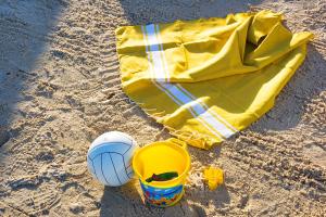 a yellow towel and a ball on the beach at AQI Skanes Resort in Monastir