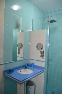y baño azul con lavabo y ducha. en Casa El lince de Granadilla, Norte provincia Cáceres, WIFI, Parque infantil, HIDROMASAJE, garaje, LAVAVAJILLAS, en Zarza de Granadilla